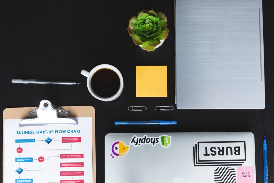 An above shot of a laptop and coffee